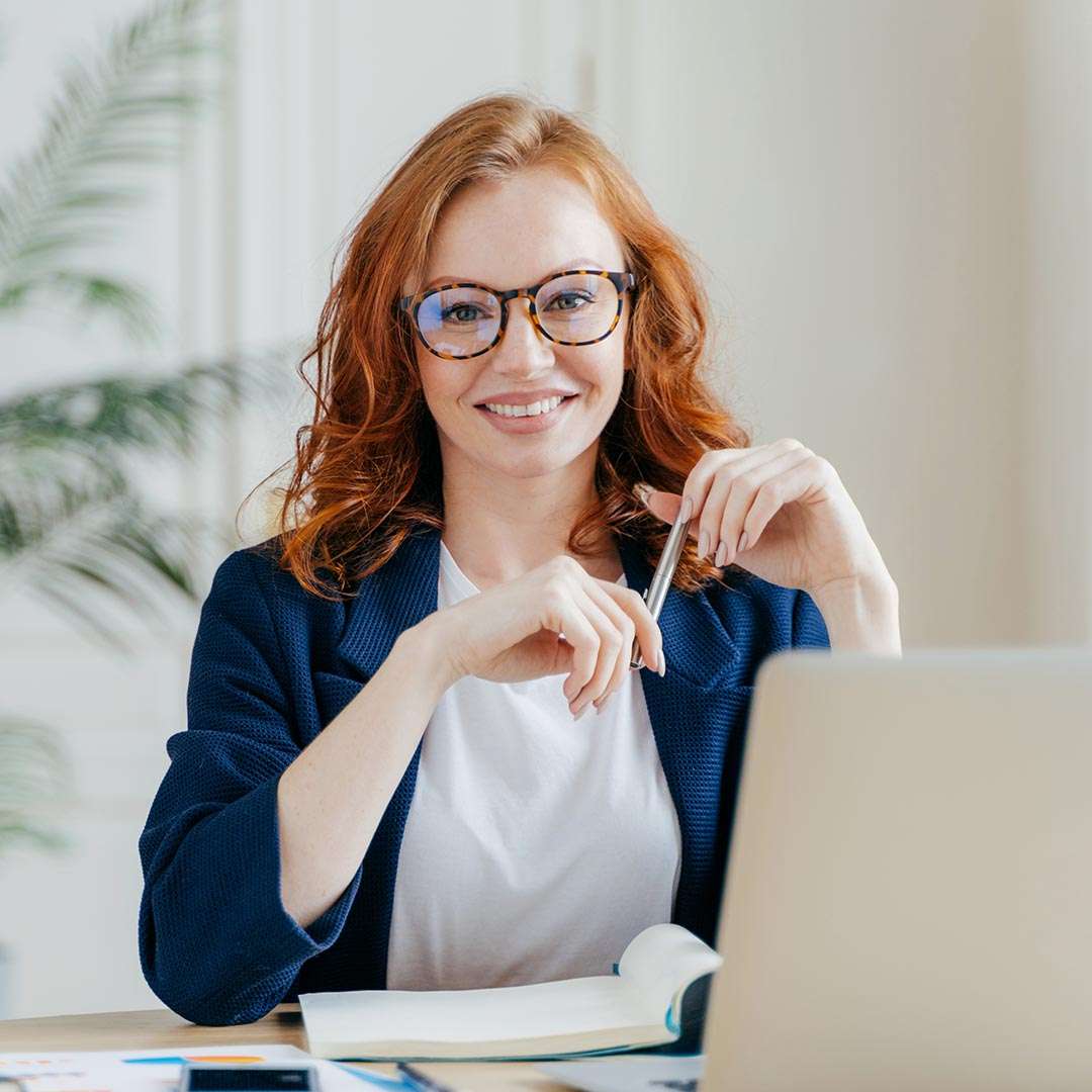 happy woman sitting at her desk